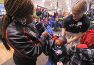 Jaquan Williams tries on a coat with help from his mother, Crystal Moyd, and John Tyson, a junior at St. Christopher’s School, during the RVA $100 for 100 shopping trip to Dick’s Sporting Goods at Short Pump Town Center. Photo: Clement Britt.